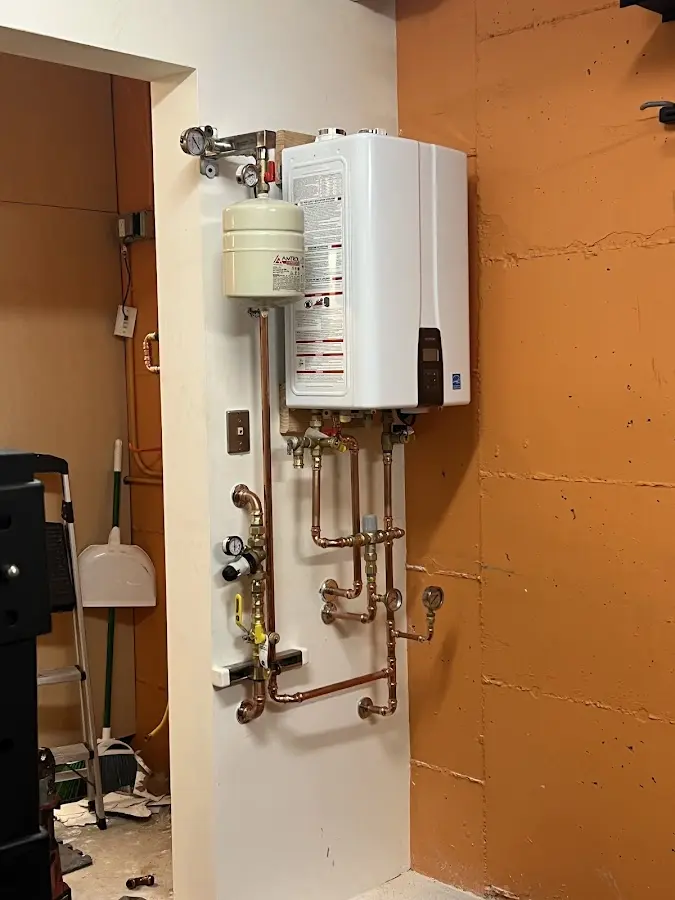 Plumbing technician inspecting water heater connections in East Marlborough